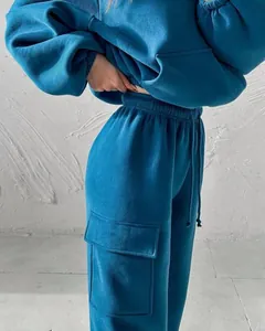 Close-up detail of teal blue fleece tracksuit showing the cargo pocket and drawstring waist