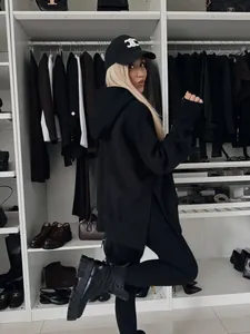 Vista de estilo de vida de un conjunto de sudadera negra oversize y pantalones para mujer.