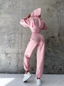 Vista posteriore dettagliata di una felpa rosa con cappuccio e pantaloni coordinati da donna