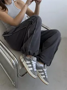 Detail view of American street style baggy grey sweatpants with contrast white stitching
