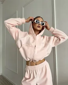 Detail van een roze sportset bestaande uit een vest met capuchon en joggingbroek