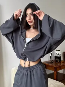 Stylish woman wearing charcoal grey two-piece set with cropped zip-up hoodie and pants