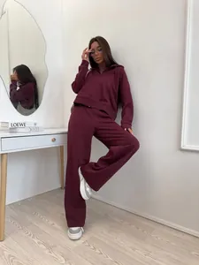Detailed view of woman in burgundy cotton zip hoodie and drawstring wide-leg pants set.