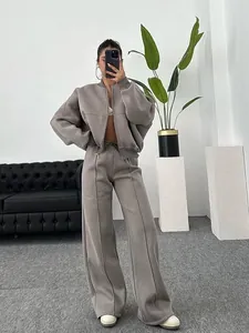 Λεπτομέρεια γυναικείας φόρμας oversize σε χρώμα taupe με ζακέτα και φαρδύ παντελόνι