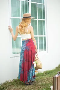 Back view of a woman wearing a vibrant printed bohemian maxi beach skirt outdoors