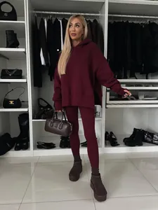 Vista de cuerpo completo de mujer con chándal con capucha extragrande en color burdeos.