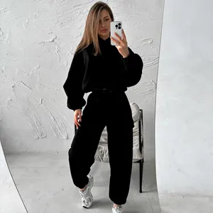 Detailed view of a woman wearing a black sporty casual hoodie and sweatpants matching set