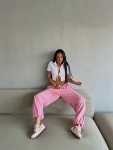 Casual lifestyle shot of women's baggy pink streetwear sweatpants with elastic waist