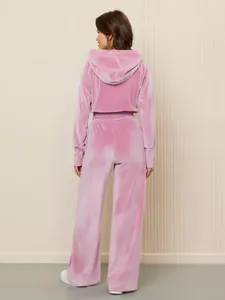 Rückansicht eines stilvollen Damen-Trainingsanzugs aus rosa Samt mit Kapuzenpullover