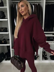 Detalle de un elegante conjunto de sudadera y leggings granate en un armario de lujo