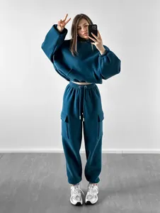 Mirror selfie of a woman wearing a teal oversized tracksuit with cargo pocket details