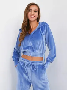 Detailaufnahme des blauen Samt-Zweiteilers mit kurzem Kapuzenpullover und Jogginghose