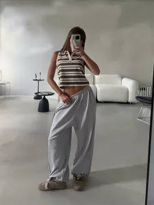 Close-up detail of grey wide-leg sweatpants styled in a minimalist interior room