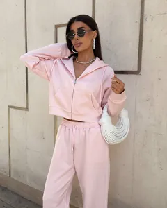 Femme portant un survêtement rose 2 pièces avec sweat à capuche zippé et pantalon