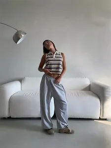 Model wearing loose American street style grey sweatpants with elastic waist.