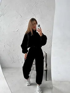 Stylish black two-piece women's sports hoodie and jogger sweat suit set on model