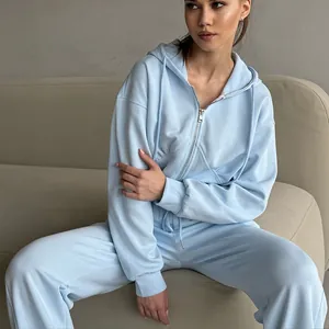 Light blue women's two-piece tracksuit set with zip-up hoodie and drawstring sweatpants.