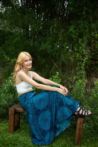 Model wearing a bohemian blue mandala print wrap maxi skirt outdoors in a lush garden setting