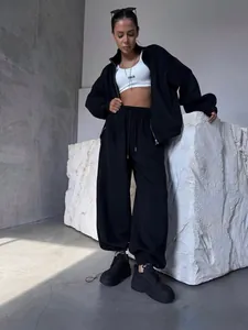 Vue détaillée de l'ensemble de détente noir deux pièces pour femme avec crop top blanc et baskets