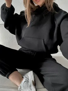 Close-up detail of a stylish black oversized hoodie and jogger tracksuit set on a model