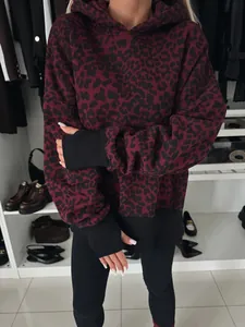 Vista detallada de sudadera con capucha de leopardo burdeos y puños de canalé negros