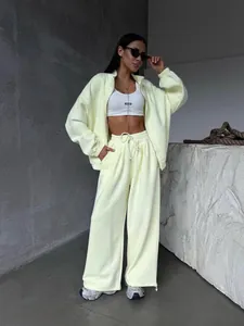 Modèle portant un ensemble de survêtement deux pièces jaune pâle avec sweat zippé