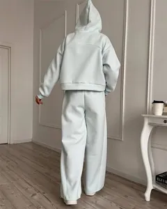Achteraanzicht van de pasvorm van een lichtblauwe tweedelige hoodie en wijde broek voor dames