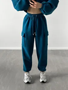 Detailed view of women's teal cargo tracksuit with cropped top and matching joggers.