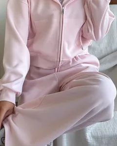 Détail d'un ensemble de survêtement rose pâle avec sweat à capuche zippé et jogging assorti