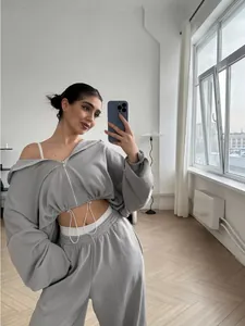 Stylish grey cropped zip-up hoodie and matching joggers set shown in a bright interior