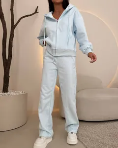 Women's light blue zip-up hoodie and sweatpants set shown in a lifestyle studio shot.