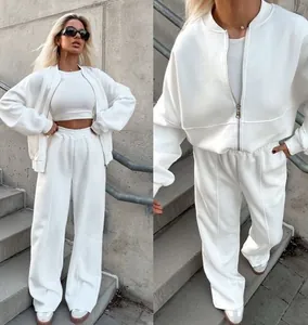 Street style εμφάνιση γυναίκας με λευκό σετ δύο τεμαχίων με ζακέτα και αθλητικό παντελόνι