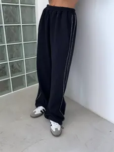 Macro detail of American street style black loose sweatpants with white contrast stitching