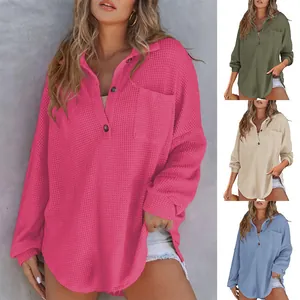 Close-up view of a women's casual waffle knit long sleeve top with pocket details