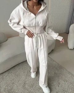 Femme portant un ensemble de loisirs en coton beige avec sweat à capuche et pantalon