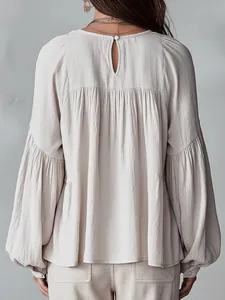 Vue détaillée du dos d'une blouse plissée beige avec d'élégantes manches lanternes