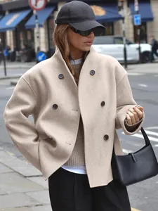 Elegante abrigo de lana beige con doble botonadura para mujer en un entorno urbano moderno