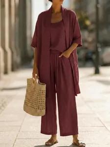 Chic deep red three-piece linen set featuring wide-leg trousers and matching cardigan