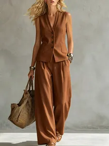 Modelo con conjunto de chaleco de lino marrón y pantalones anchos con bolso de rayas.