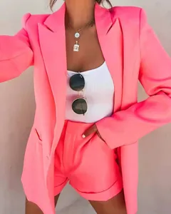 Detail view of a stylish vibrant pink blazer and shorts set with a white ribbed top.