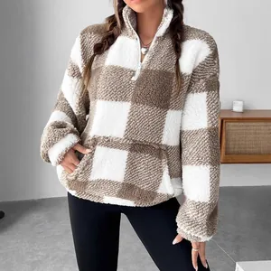 Vista detallada de la suave textura de forro polar a cuadros de esta sudadera con media cremallera.
