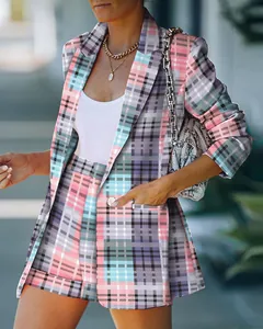 Close-up detail of stylish pink and blue plaid women's blazer and matching shorts.