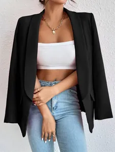 Primer plano de un elegante blazer negro para mujer sobre un top corto blanco chic