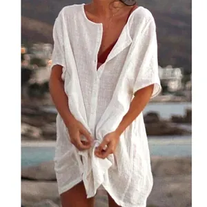 Detail view of a loose white linen-style beach cover-up shirt with front buttons