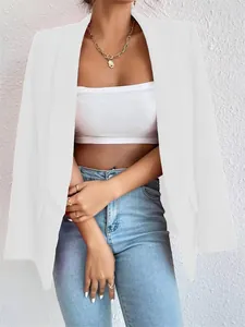 Vista detallada de un elegante blazer blanco de mujer con jeans azules y collar dorado