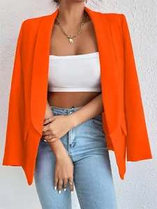 Chaqueta blazer naranja vibrante para mujer, combinada con top blanco y vaqueros azules.