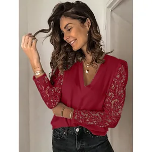 Detail view of burgundy V-neck top featuring elegant lace patchwork on long sleeves.