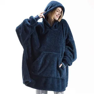 Cozy texture detail of a navy blue fleece wearable blanket hoodie on a female model