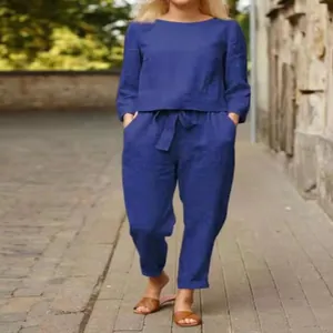 Donna che indossa un semplice completo a due pezzi in lino blu in ambiente esterno