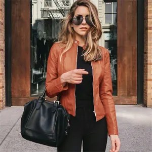 Modelo luciendo una elegante chaqueta de cuero PU naranja con conjunto negro en la calle